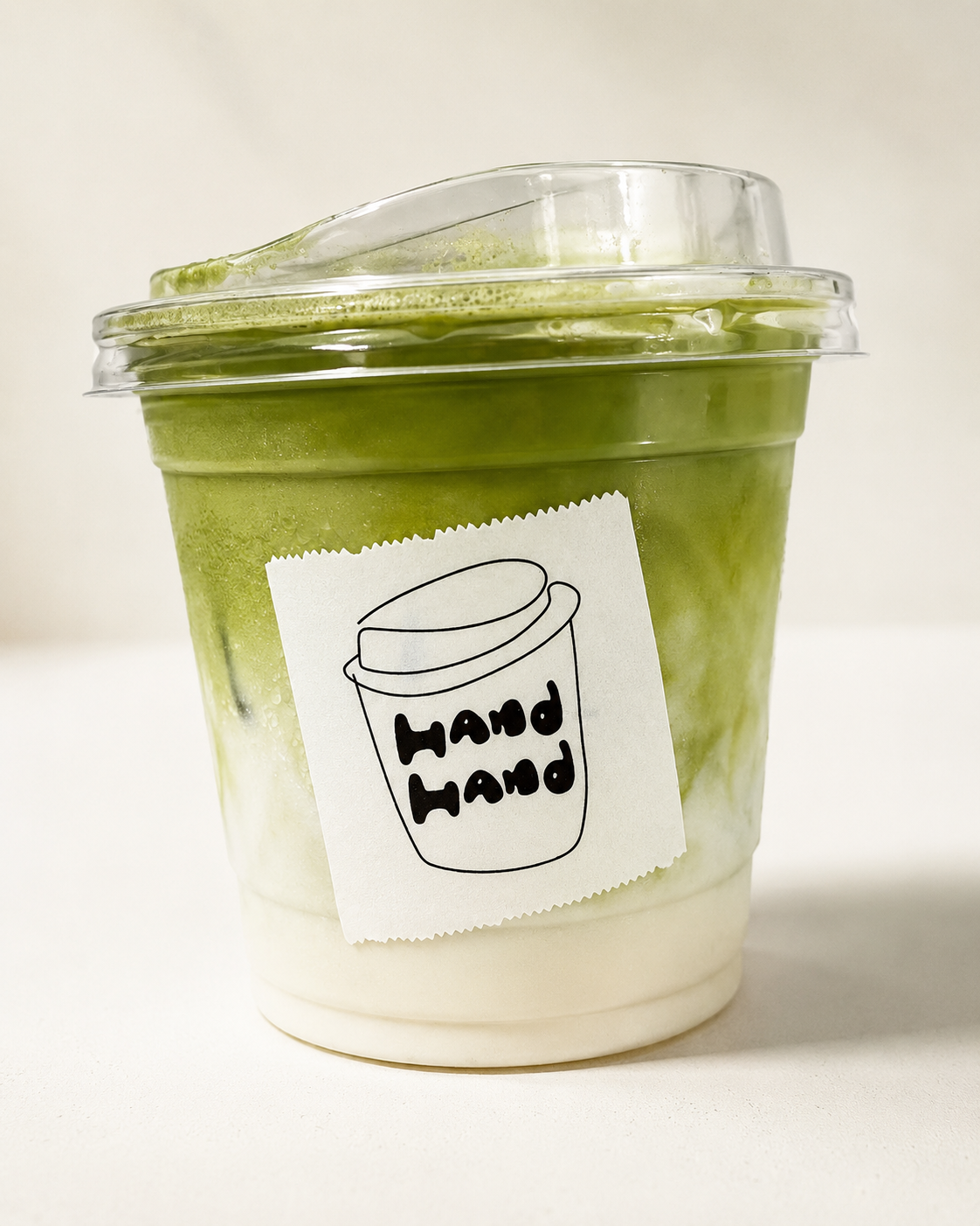 Green tea latte with Hand Hand Coffee label