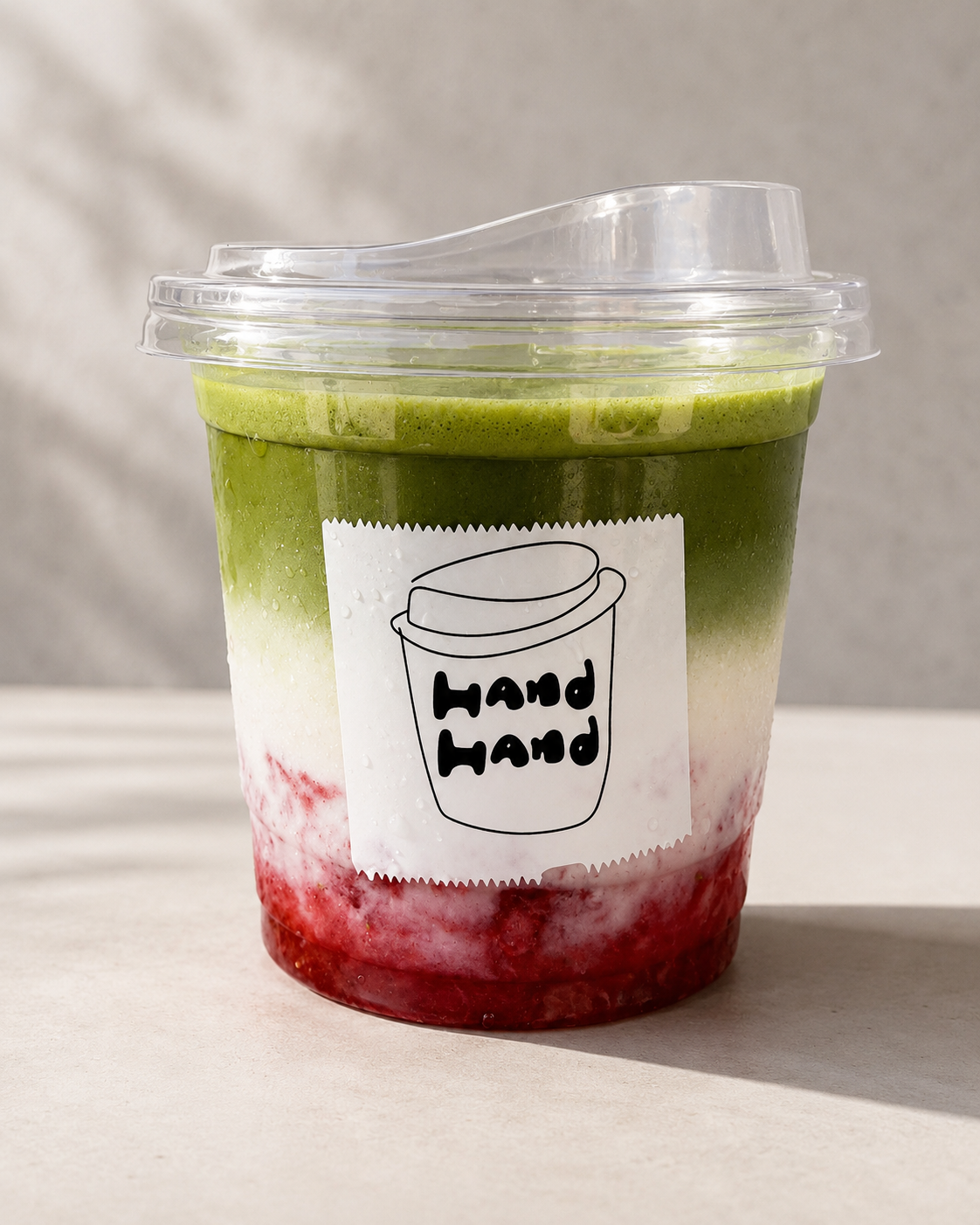 Layered strawberry matcha drink from Hand Hand Coffee